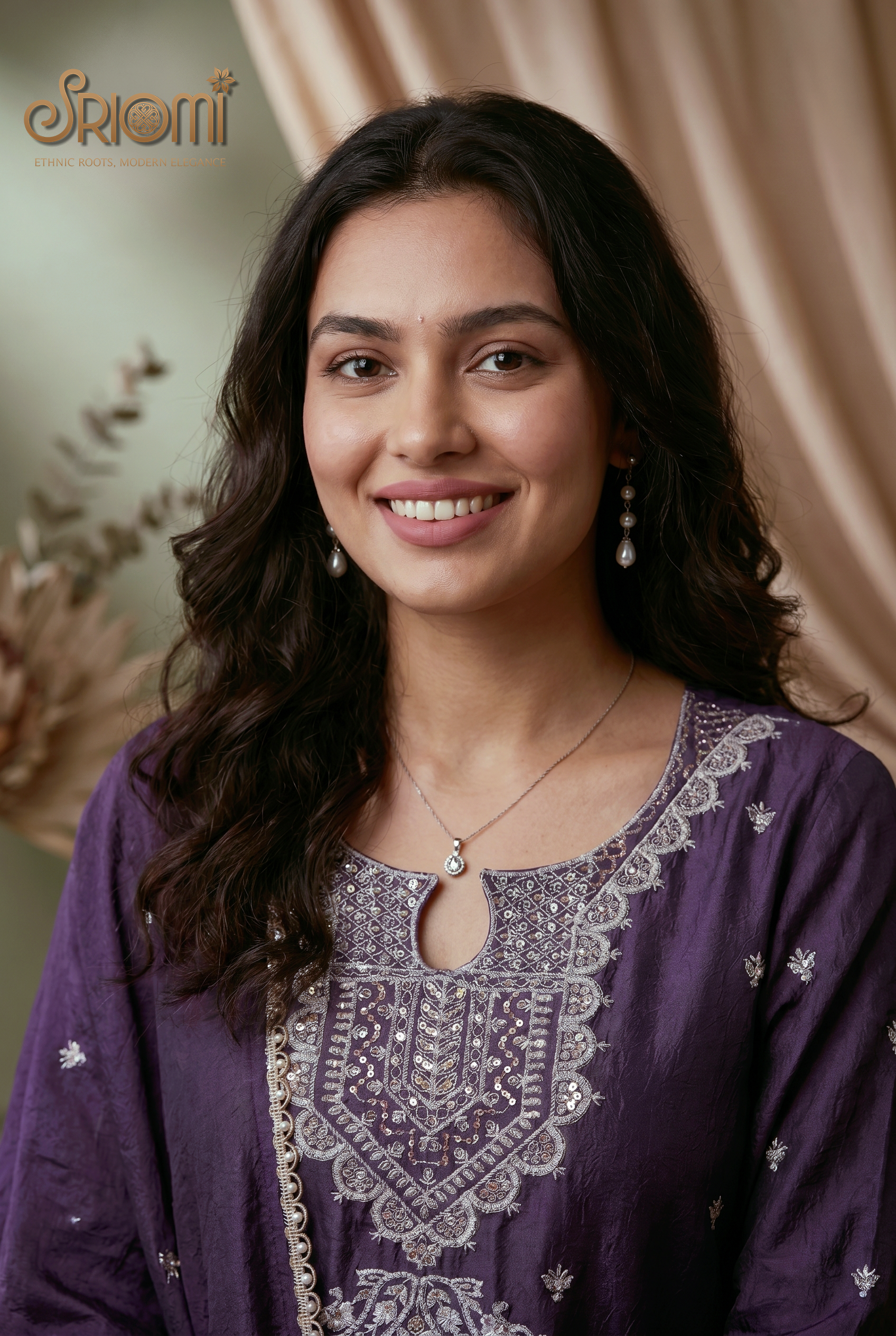 Woman wearing a purple embroidered outfit with a beige curtain background