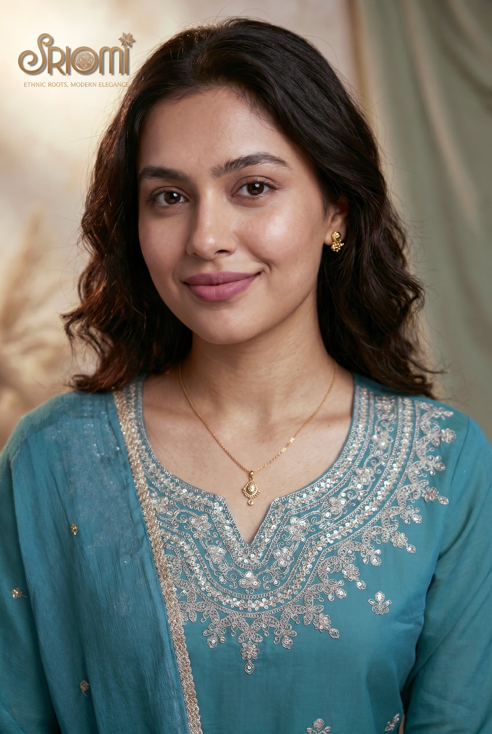 Woman wearing a blue embroidered outfit with a neutral background