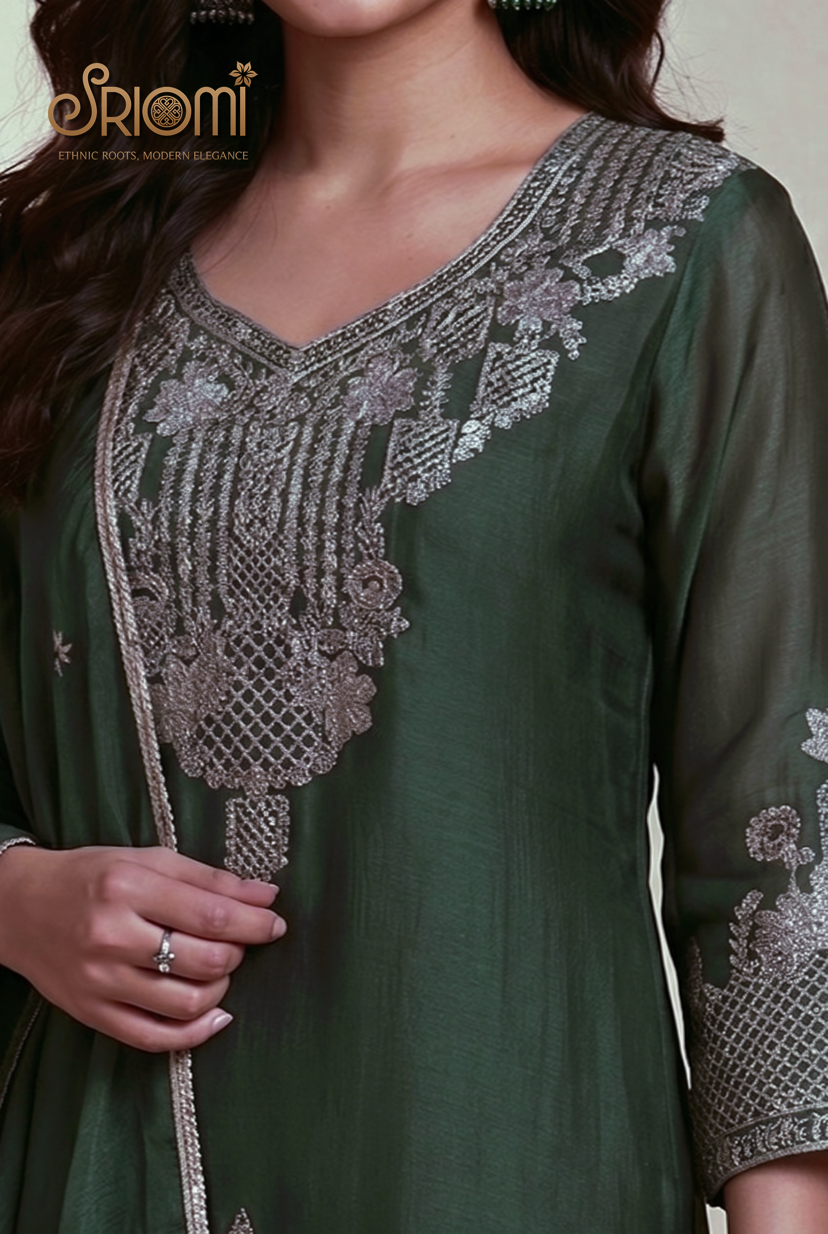 Green embroidered dress with silver detailing on a neutral background